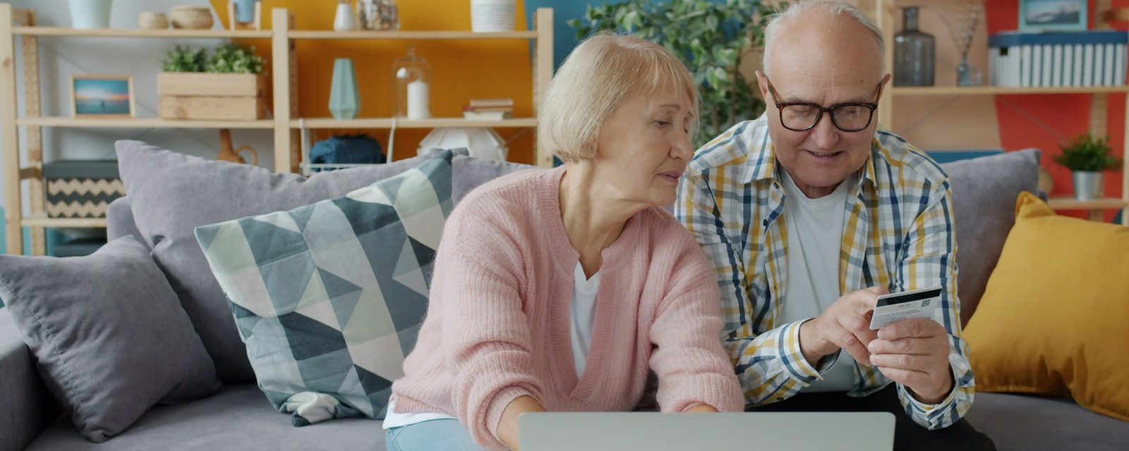 Una pareja mayor revisa algo juntos en su computadora